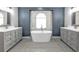 Modern bathroom with freestanding tub, double vanity, and decorative tile floor at 1303 Casey Key Dr, Punta Gorda, FL 33950