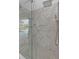 Luxurious bathroom with walk-in shower featuring rainfall shower head, stone wall and views of outdoor pool at 1303 Casey Key Dr, Punta Gorda, FL 33950