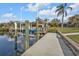 Waterfront view showcasing the concrete dock and boat lift system with manicured lawn extending to the water's edge at 1303 Casey Key Dr, Punta Gorda, FL 33950