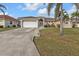Charming single-story home with a well-maintained lawn, arched windows, and a spacious two-car garage at 1303 Casey Key Dr, Punta Gorda, FL 33950