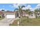 Charming home featuring a well-manicured lawn, mature palms, and a convenient two-car garage at 1303 Casey Key Dr, Punta Gorda, FL 33950