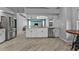 White kitchen with stainless steel appliances and light colored countertops open to the living room and dining area at 1303 Casey Key Dr, Punta Gorda, FL 33950