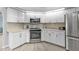 Bright kitchen with white cabinets, stainless steel appliances, tile backsplash, and light-colored countertops at 1303 Casey Key Dr, Punta Gorda, FL 33950