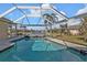 Beautiful pool with screened enclosure and waterfront views on a sunny day in this luxury home's backyard at 1303 Casey Key Dr, Punta Gorda, FL 33950