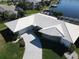 Aerial shot of the house with a well-maintained white tile roof, lush landscaping, and a paved driveway at 1407 Waxwing Ct, Punta Gorda, FL 33950