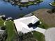 Overhead angle of house with white tile roof and boat dock along a canal, surrounded by green grass at 1407 Waxwing Ct, Punta Gorda, FL 33950