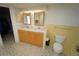 This bathroom features a double vanity, decorative tile flooring, and a toilet with yellow tiling at 1407 Waxwing Ct, Punta Gorda, FL 33950