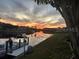 Dock view of a canal with boats, a steller MLS logo, and a vivid sunset in the sky at 1407 Waxwing Ct, Punta Gorda, FL 33950