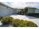 Front exterior showing a well-kept home with white brick, rock accents, tidy landscaping, and a paved driveway at 1407 Waxwing Ct, Punta Gorda, FL 33950