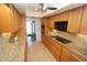 A kitchen featuring wood cabinets, granite countertops, and a ceiling fan at 1407 Waxwing Ct, Punta Gorda, FL 33950