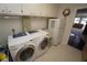 Laundry room with washer, dryer, sink, overhead storage, and a small refrigerator at 1407 Waxwing Ct, Punta Gorda, FL 33950