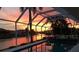 Screened pool, sunset, palm trees and canal view at 1407 Waxwing Ct, Punta Gorda, FL 33950