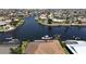 Aerial view showcasing waterfront homes along the canal, many with private docks, boat lifts, and pools at 1492 Aqui Esta Dr, Punta Gorda, FL 33950