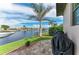 Waterfront backyard featuring a barbeque grill and lush tropical landscaping at 1492 Aqui Esta Dr, Punta Gorda, FL 33950