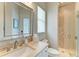 Elegant bathroom with a stone tiled shower, sleek countertops, and plenty of natural light at 1492 Aqui Esta Dr, Punta Gorda, FL 33950