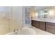 Elegant bathroom with a soaking tub, marble wall shower, and modern vanity with sink at 1492 Aqui Esta Dr, Punta Gorda, FL 33950