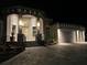 Exterior front elevation with beautifully lit entrance, detailed archways, and a paver driveway at 1492 Aqui Esta Dr, Punta Gorda, FL 33950
