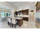 Gourmet kitchen featuring stainless steel appliances, custom cabinetry, large island, and a view of the dining area at 1492 Aqui Esta Dr, Punta Gorda, FL 33950
