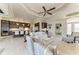 Open concept living room with high ceilings, tile flooring, modern furniture and adjoining kitchen with a bar counter at 1492 Aqui Esta Dr, Punta Gorda, FL 33950