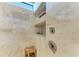 Walk in shower featuring marble walls, built-in shelving and a rain fall shower head at 1492 Aqui Esta Dr, Punta Gorda, FL 33950