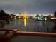 Waterfront view overlooking a canal, palm trees, boat docks, and manicured lawns at 1492 Aqui Esta Dr, Punta Gorda, FL 33950