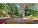 Serene backyard featuring a wooden deck surrounded by lush tropical plants and trees at 1525 Hinton St, Port Charlotte, FL 33952
