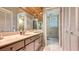 Bathroom featuring a vanity with sink, wallpaper, mirror, cabinets, and an adjoining toilet room at 1525 Hinton St, Port Charlotte, FL 33952