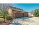 A three car garage with brown doors and siding, a blue sky and some trees at 1525 Hinton St, Port Charlotte, FL 33952