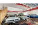 Multiple classic cars parked inside this spacious garage with an epoxy floor and a red beam at 1525 Hinton St, Port Charlotte, FL 33952