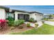 Well-maintained home with vibrant landscaping, a paved walkway, and an inviting entrance, offering a warm welcome to visitors at 16265 Juarez Cir, Punta Gorda, FL 33955