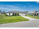 Charming home featuring a well-manicured lawn, colorful landscaping, and a paved driveway leading to the attached two-car garage at 16265 Juarez Cir, Punta Gorda, FL 33955