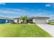 Charming one-story home with lush landscaping and a well-manicured lawn at 16265 Juarez Cir, Punta Gorda, FL 33955