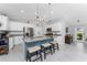 Modern kitchen featuring white cabinets, granite countertops, a stylish blue island with seating, and stainless steel appliances at 16265 Juarez Cir, Punta Gorda, FL 33955