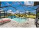 Inviting screened-in pool area with pavers, lounge chair, and lush landscaping, perfect for relaxation and outdoor enjoyment at 16265 Juarez Cir, Punta Gorda, FL 33955