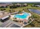 Aerial view showcases a community pool with a clubhouse, tennis courts, and ample seating at 175 Kings Hwy # 538, Punta Gorda, FL 33983