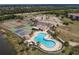 Aerial view of community pool, tennis courts, and nearby parking at 175 Kings Hwy # 538, Punta Gorda, FL 33983