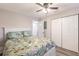 Cozy bedroom features a floral comforter, ceiling fan, and ample closet space for optimal storage at 175 Kings Hwy # 538, Punta Gorda, FL 33983