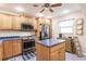 Bright kitchen features wood cabinets, stainless appliances, and center island with blue countertops at 175 Kings Hwy # 538, Punta Gorda, FL 33983