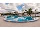 Beautiful community pool surrounded by lounge chairs and tropical palm trees at 175 Kings Hwy # 538, Punta Gorda, FL 33983