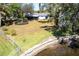 The backyard features a lush green lawn, mature trees, and a screened-in porch providing a private outdoor retreat at 18379 Meyer Ave, Port Charlotte, FL 33948