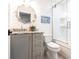Cozy bathroom features shiplap walls, gray vanity with marble countertop, round mirror, and a glass-enclosed shower at 18379 Meyer Ave, Port Charlotte, FL 33948
