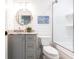 Charming bathroom showcases shiplap walls, gray vanity with marble top, round mirror, and glass-enclosed shower at 18379 Meyer Ave, Port Charlotte, FL 33948