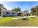Charming single-story home featuring a well-manicured lawn with stone decorations, a concrete driveway and mature trees at 18379 Meyer Ave, Port Charlotte, FL 33948