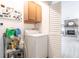 Convenient laundry room with washer, dryer, storage shelves, and access to a bright, inviting living area at 18379 Meyer Ave, Port Charlotte, FL 33948