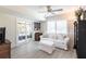 Comfortable living room featuring white furnishings, sliding glass doors, and a ceiling fan at 18379 Meyer Ave, Port Charlotte, FL 33948