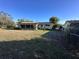 View of the home's backyard showing the screened patio, lawn, and fenced area at 20262 Hamilton Ave, Port Charlotte, FL 33952