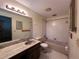 Functional bathroom with a vanity, toilet, and a shower-tub combination with tiled walls at 20262 Hamilton Ave, Port Charlotte, FL 33952