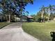 Well-manicured lawn with mature trees enhances the curb appeal of this home with an attached garage at 20262 Hamilton Ave, Port Charlotte, FL 33952