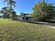 View of the home's front yard with a long driveway and mature shade trees at 20262 Hamilton Ave, Port Charlotte, FL 33952