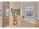 Bathroom featuring glass-enclosed shower and corner garden tub with tile surround at 2051 Snover Ave, North Port, FL 34286